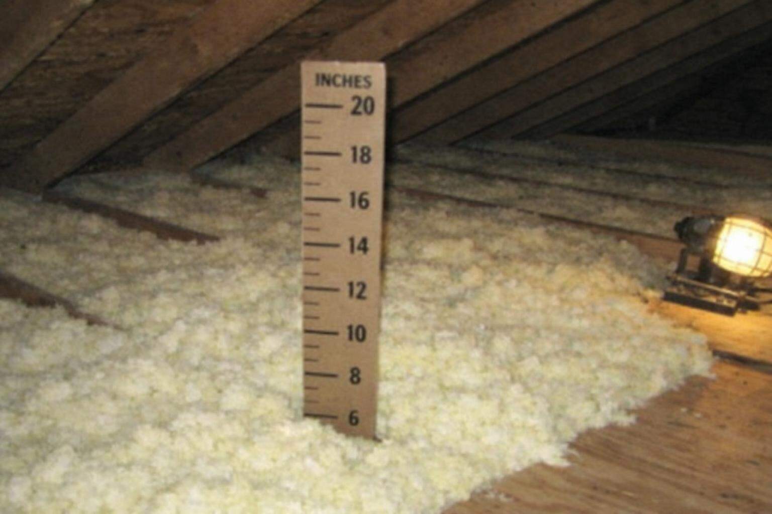 Fresh blown-in insulation filling the joist bays of an attic