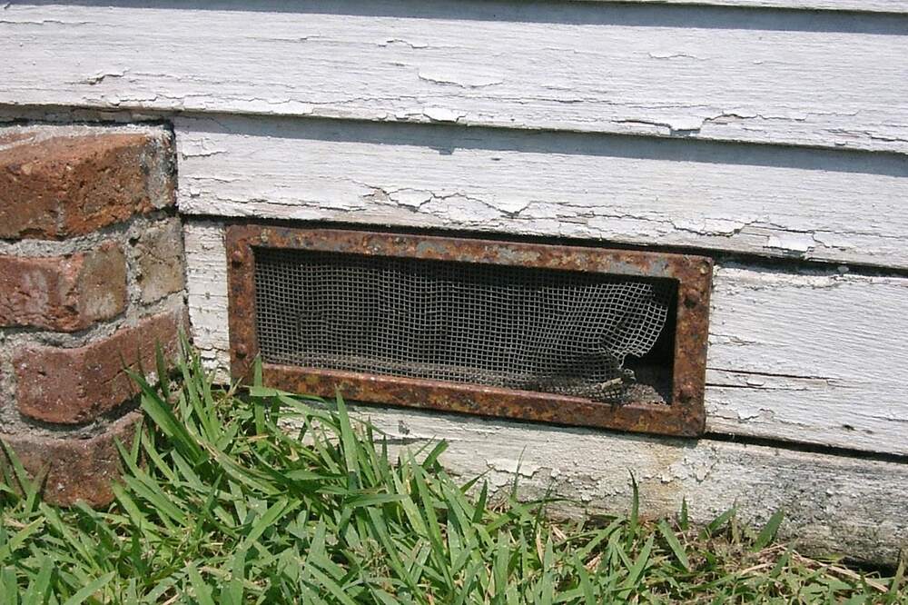 The skirting and foundation vent of an older wood-frame house