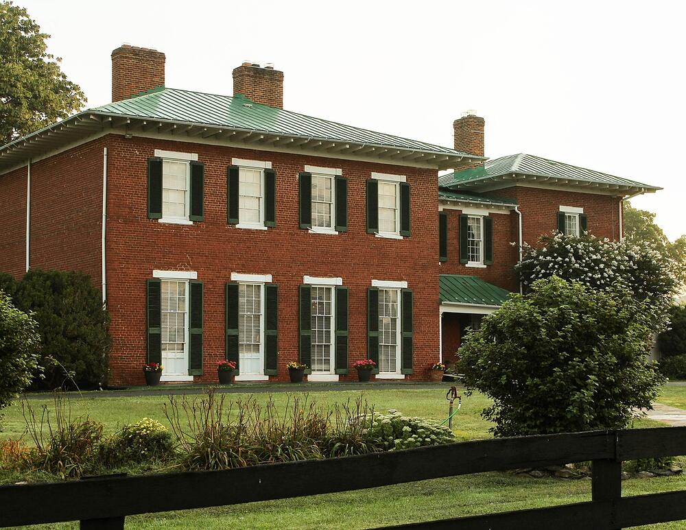 A 1920s house with a slate roof and mature landscaping